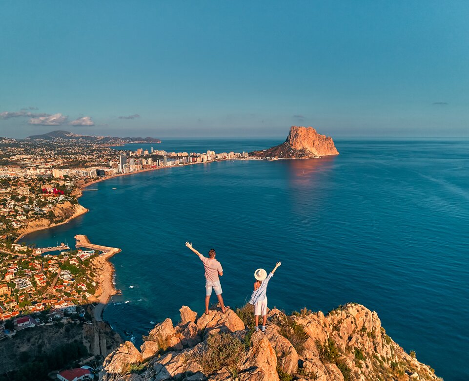Blick von einem Felsen auf Alicante mit winkendem Parr im Vordergrund | © Envato Elements